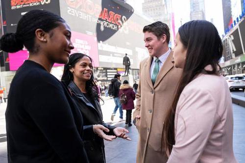 Students talk 和 smile in Times Square.